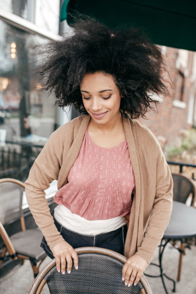 woman outside pulling back a table chair about to sit for lunch