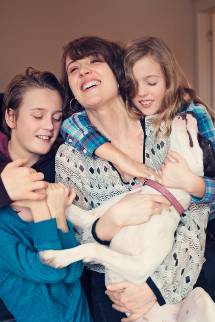 A mom and three kids and a dog laughing