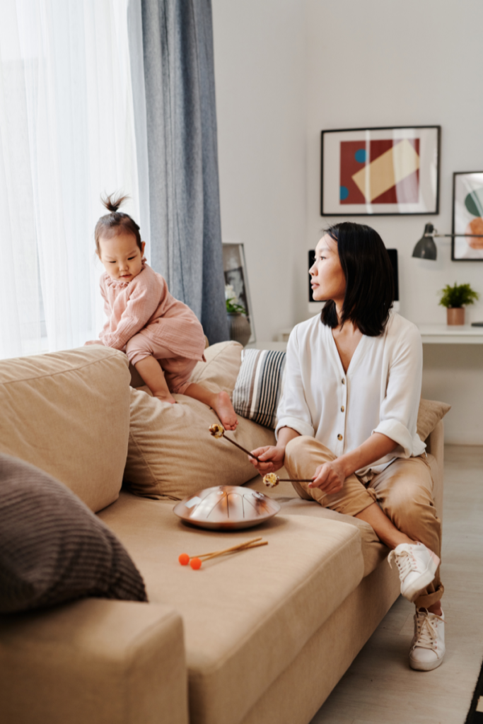 mom and baby on the couch playing with a sound toy