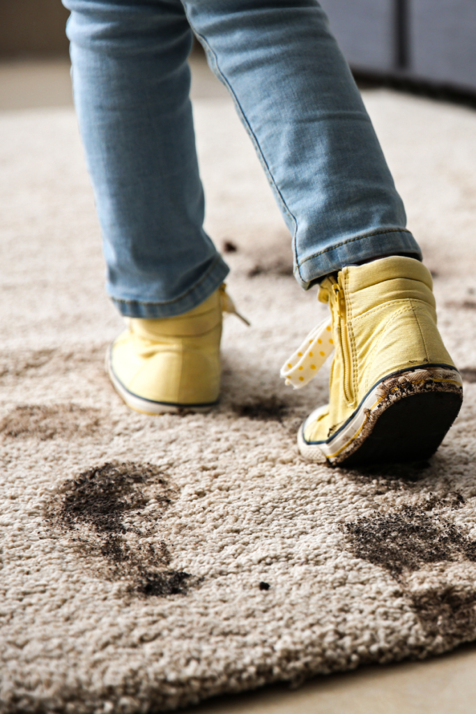 Little girl walking on carpet with muddy shoes