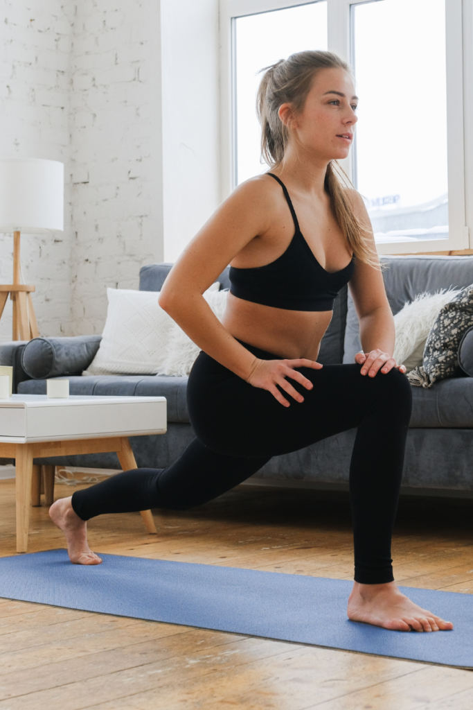 woman doing a yoga pose in a living room on a blue mat