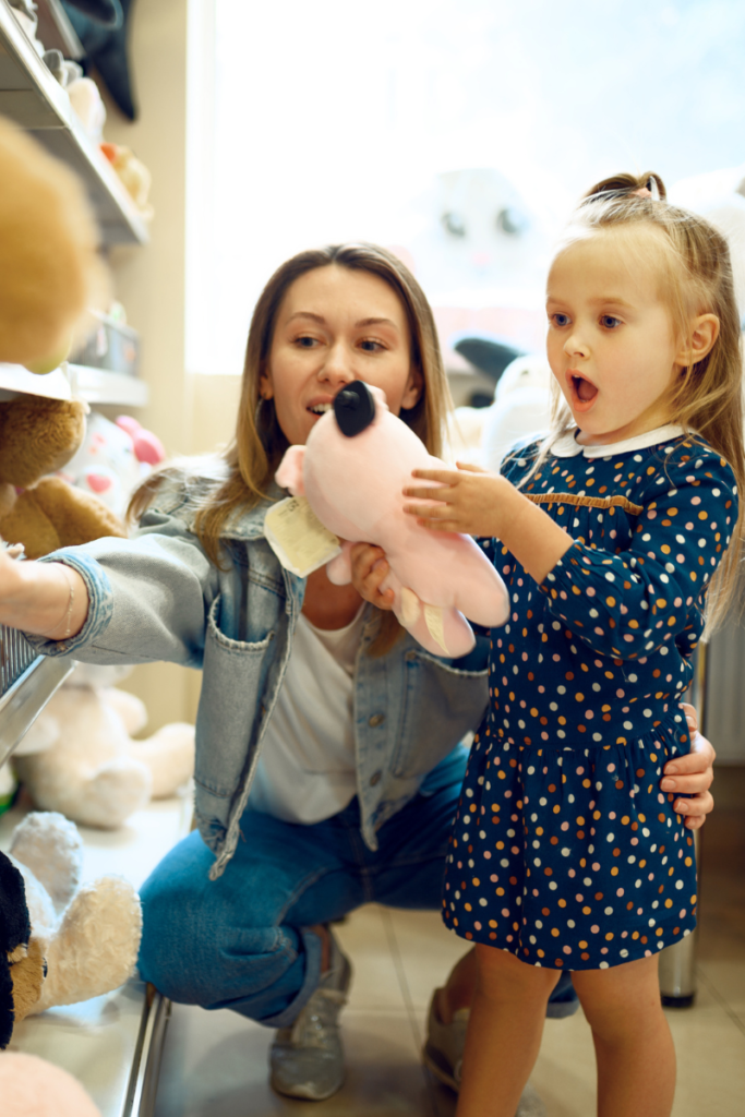 mom and daughter picking out a stuffed animal at the store - the power of saying yes